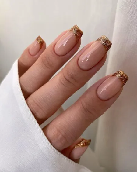 Nude nails with delicate gold foil accents.