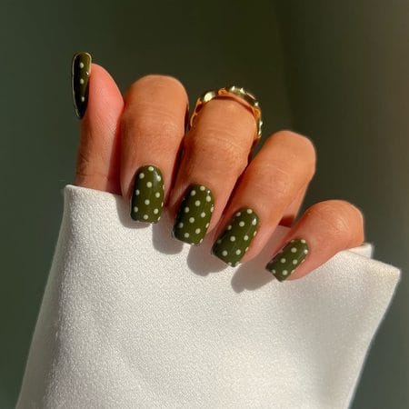 Creamy olive green short square nails accented with uniform white polka dots