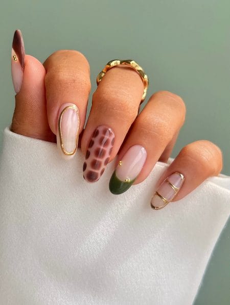 Oval nails combining amber tortoiseshell patterns, forest green lacquer, and raised 3D molten gold framing