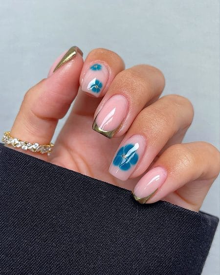 Crisp square nails with metallic bronze French tips and airbrushed teal floral accents