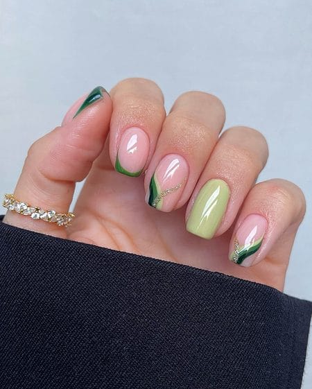 Short square nails featuring earthy sage and forest green swirls outlined with fine gold glitter
