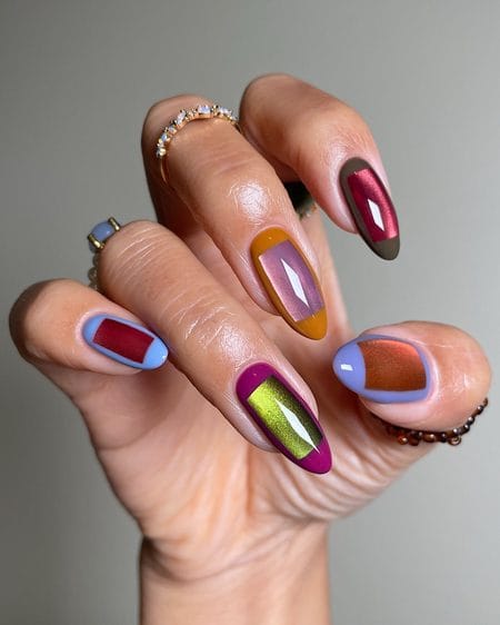 Colour-blocked almond nails featuring rectangular velvet cat-eye centres framed by mustard, plum, and periwinkle