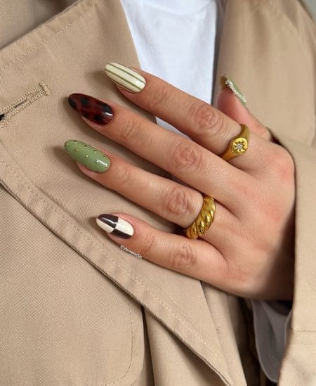 Autumn almond nails displaying sage green with studs, dark tortoiseshell, olive pinstripes, and chocolate checks