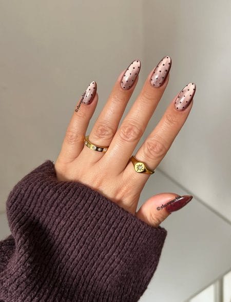 Rose gold metallic velvet almond nails decorated with neat dark chocolate polka dots