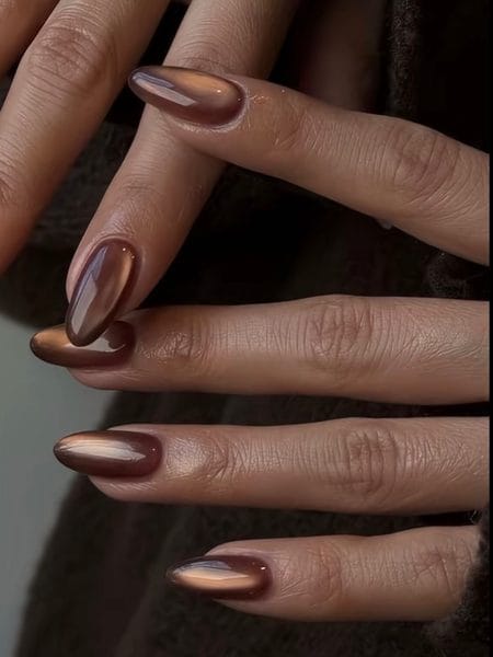 Translucent amber syrup almond nails with a glowing horizontal magnetic cat-eye band