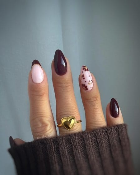 Oxblood brown almond nails with blush florals and a gold French tip