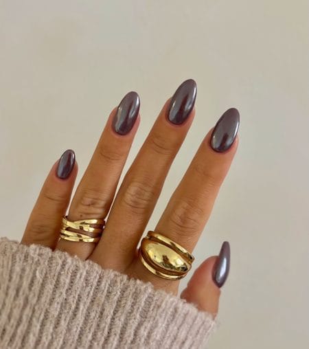 Taupe-brown almond nails with a reflective bronze chrome finish