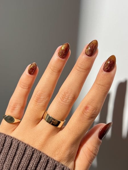 Honey amber nails with golden shimmer and a translucent glossy finish