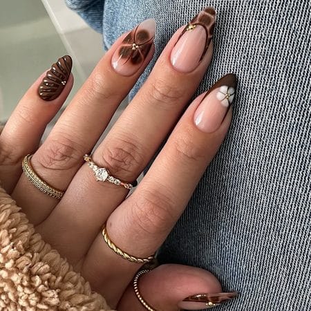 Mahogany French tip nails with 3D ribbed texture, floral details, and gold beads