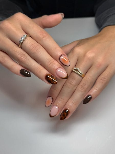Honey tortoiseshell almond nails with amber French tips and espresso accents