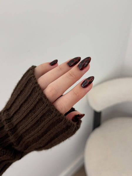 Dark espresso tortoiseshell almond nails with black-brown spots
