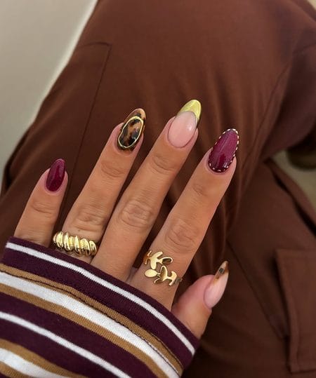Berry shimmer nails with a tortoiseshell accent and molten gold frame