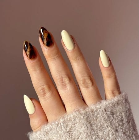 Butter yellow nails with glossy amber and black tortoiseshell accents