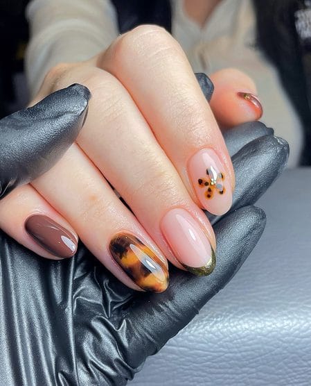 Pink nails with a tortoiseshell flower and delicate gold French tip