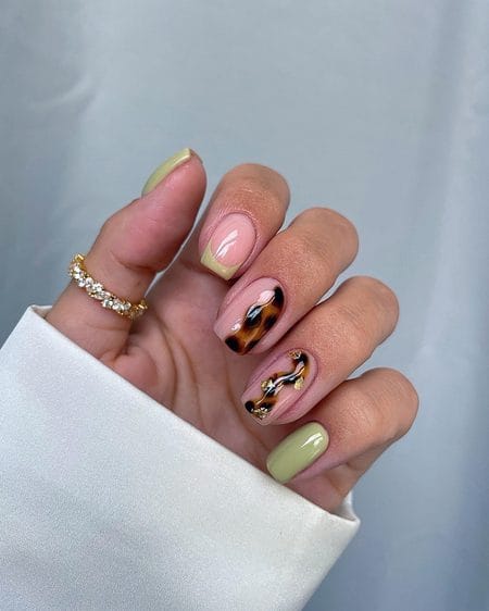 Pistachio green nails with tortoiseshell marble ribbons and gold leaf