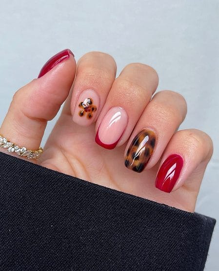 Ruby red French nails with tortoiseshell daisy accent details