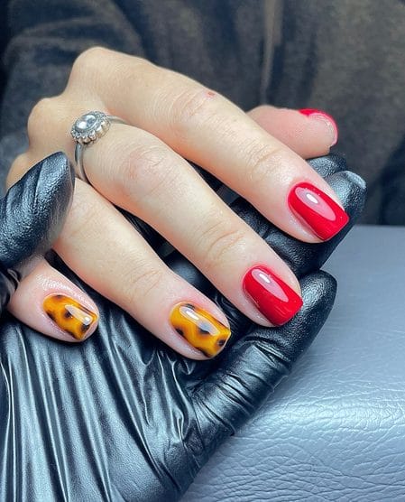 Glossy pillar box red nails with honey amber tortoiseshell accents