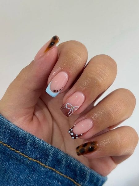 Pastel blue French tip nails with tortoiseshell bows and dotted details