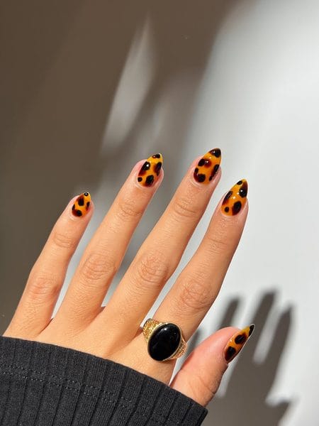 Golden ochre almond nails with dark espresso blooming tortoiseshell spots
