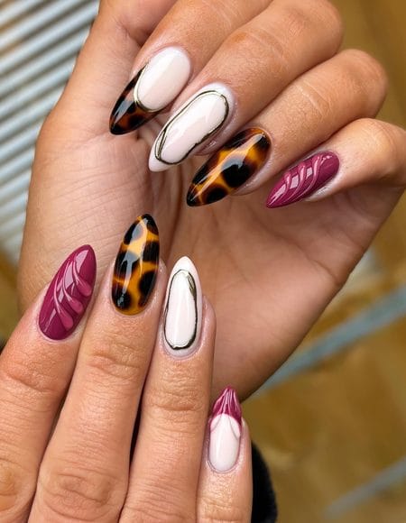Plum stiletto nails with 3D swirls and gilded tortoiseshell accent