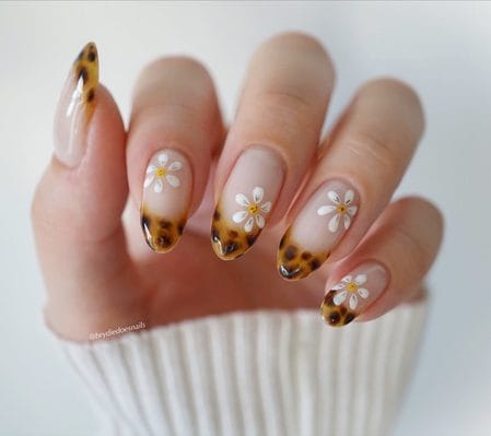 Long almond nails with tortoiseshell French tips and white daisy details